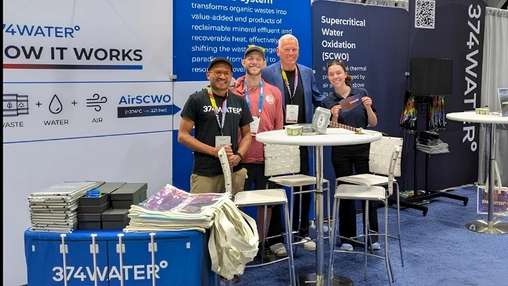 374Water exhibition stand at a conference showing the AirSCWO system with four staff members posing together